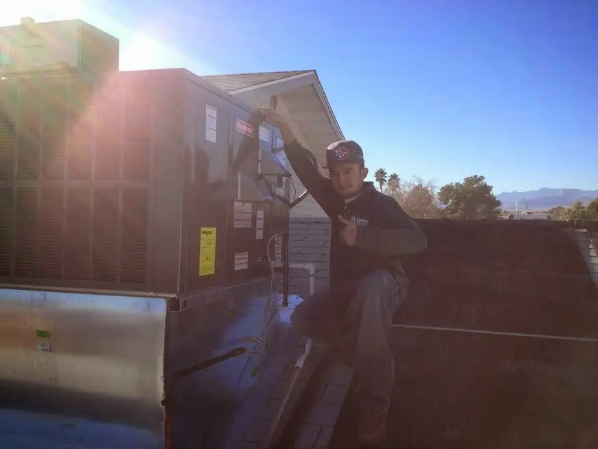 HVAC technician performing AC Tune-Up on a rooftop unit in Walnut